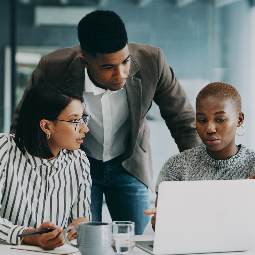 Diverse coworkers discussing Agile assessment on laptop screen