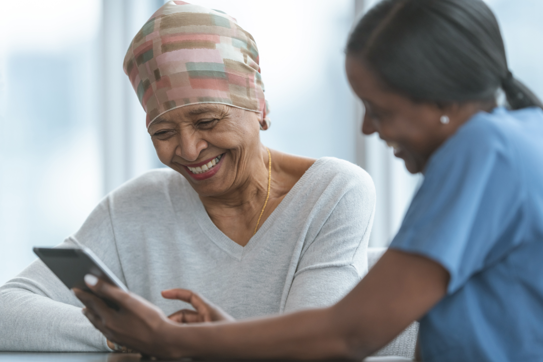 Senior African American cancer patient walking through diagnosis on tablet with doctor, an essential part of design thinking for healthcare nonprofit