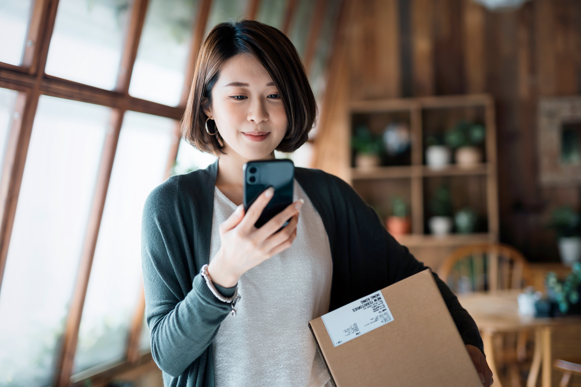 Asian woman purchasing package from mobile device